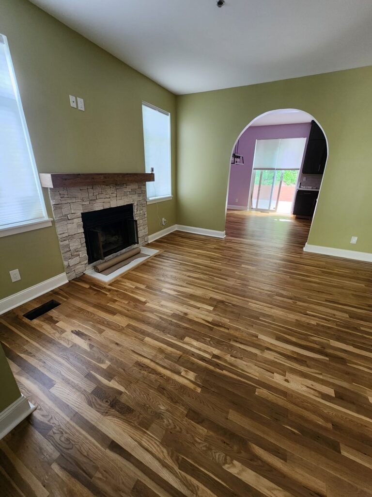 Finished living room with fireplace and refinished hardwood floors in a Dobbs Ferry home renovation