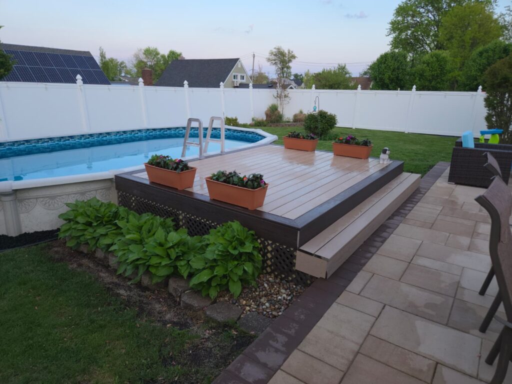 Composite pool deck with patio and backyard landscaping for a Staten Island home.